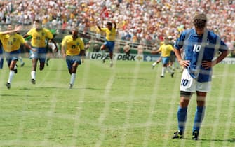 APP2001032629068 LOS ANGELES, UNITED STATES: Brazilian players run to join their teammates as Italian midfielder Roberto Baggio bows his head after he missed his penalty kick giving Brazil a 3-2 victory in the shoot-out session (0-0 after extra time) at the end of the World Cup final, 17 July 1994 at the Rose Bowl in Pasadena. Brazil won its fourth World Cup title after 1958, 1962 and 1970. AFP PHOTO/OMAR TORRES (Photo credit should read OMAR TORRES/AFP/Getty Images)