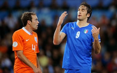 Italian forward Luca Toni gestures to Dutch defender Joris Mathijsen (L) during their Euro 2008 Championships Group C football match the Netherlands vs. Italy on June 9, 2008 at the stade de Suisse in Bern.    AFP PHOTO / PIERRE-PHILIPPE MARCOU      -- MOBILE SERVICES OUT --           (Photo credit should read PIERRE-PHILIPPE MARCOU/AFP via Getty Images)