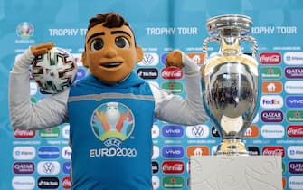 epa09158643 The UEFA EURO 2020 mascot Skillzy poses with the EURO Trophy during a presentation ceremony held at National Arena stadium in Bucharest, Romania, 25 April 2021, as the UEFA Euro 2020 Trophy Tour arrives. Bucharest is one of the host cities of the UEFA EURO 2020, which was postponed one year due to Covid-19.  EPA/ROBERT GHEMENT