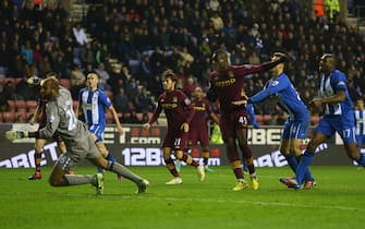 WIGAN, ENGLAND - NOVEMBER 28:  Mario Balotelli (3R) of Manchester City  scores his sides opening goal during the Barclays Premier League match between Wigan Athletic and Manchester City at the DW Stadium on November 28, 2012 in Wigan, England.  (Photo by Michael Steele/Getty Images)