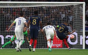 epa10700836 Kylian Mbappe (R) of France scores the 1-0 goal from the penalty spot during the UEFA EURO 2024 qualification match between France and Greece in Saint-Denis, France, 19 June 2023.  EPA/MOHAMMED BADRA