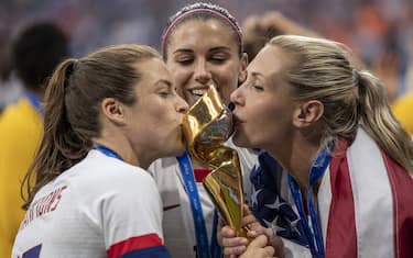 LYON, FRANCE - JULY 07: Kelley O'hara, Alex Morgan and Allie Long of the USA celebrate with the FIFA Women's World Cup Trophy following the 2019 FIFA Women's World Cup France Final match between The United States of America and The Netherlands at Stade de Lyon on July 07, 2019 in Lyon, France. (Photo by Maja Hitij/Getty Images)