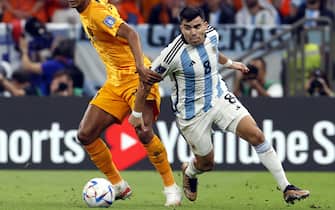 epa10358034 Cody Gakpo (L) of the Netherlands in action against Marcos Acuna of Argentina during the FIFA World Cup 2022 quarter final soccer match between the Netherlands and Argentina at Lusail Stadium in Lusail, Qatar, 09 December 2022.  EPA/Rungroj Yongrit