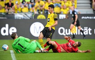 epa09413896 Dortmund's Giovanni Reyna (C) in action against Frankfurt's goalkeeper Kevin Trapp (L) and Stefan Ilsanker (R) during the German Bundesliga soccer match between Borussia Dortmund and Eintracht Frankfurt in Dortmund, Germany, 13 August 2021.  EPA/SASCHA STEINBACH CONDITIONS - ATTENTION: The DFL regulations prohibit any use of photographs as image sequences and/or quasi-video.