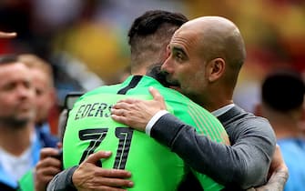 Manchester City's goalkeeper Ederson (left) and manager Pep Guardiola (right) celebrates victory after the FA Cup Final at Wembley Stadium, London.