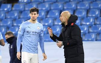 Manchester City's John Stones talks with manager Pep Guardiola during the Premier League match at the Etihad Stadium, Manchester.