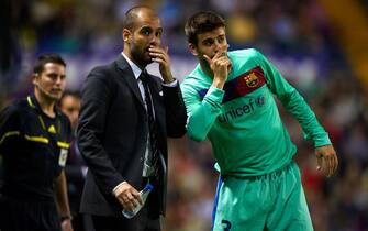 VALENCIA, SPAIN - MAY 11:  Head Coach Josep Guardiola (L) of Barcelona gives instructions to Gerard Pique during the La Liga match between Levante UD and Barcelona at Ciutat de Valencia on May 11, 2011 in Valencia, Spain. The match ended 1-1.  (Photo by Manuel Queimadelos Alonso/Getty Images)
