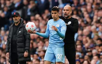 Manchester City manager Pep Guardiola embraces Joao Cancelo on the touchline during the Premier League match at the Etihad Stadium, Manchester. Picture date: Sunday April 10, 2022.