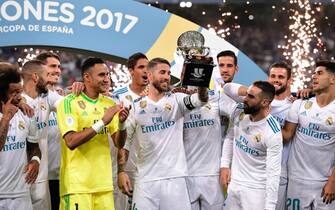 Real Madrid's defender Sergio Ramos (C) holds up the trophy as he and teammates celebrate their Supercup after winning the second leg of the Spanish Supercup football match Real Madrid vs FC Barcelona at the Santiago Bernabeu stadium in Madrid, on August 16, 2017. / AFP PHOTO / JAVIER SORIANO        (Photo credit should read JAVIER SORIANO/AFP/Getty Images)