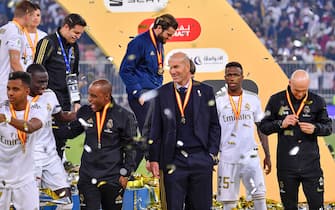 Real Madrid's French coach Zinedine Zidane (C) watches his players carry the trophy after winning the Spanish Super Cup final between Real Madrid and Atletico Madrid on January 12, 2020, at the King Abdullah Sports City in the Saudi Arabian port city of Jeddah. (Photo by Giuseppe CACACE / AFP) (Photo by GIUSEPPE CACACE/AFP via Getty Images)