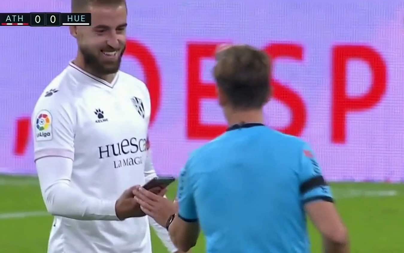 Con un sorriso, Pulido consegna all'arbitro il cellulare trovato in campo Pulido