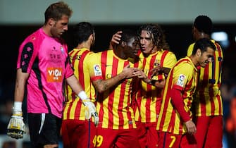 CARTAGENA, SPAIN - DECEMBER 06:  Dongou (2L) of Barcelona celebrates with his teammate Carles Puyol  during the Copa del Rey Round of 32 match between FC Cartagena and FC Barcelona at Estadio Cartagonova on December 06, 2013 in Cartagena, Spain.  (Photo by Manuel Queimadelos Alonso/Getty Images)