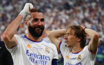 Real Madrid's French forward Karim Benzema and Luka Modric (bacground) celebrate at the end of the UEFA Champions League final football match between Liverpool and Real Madrid at the Stade de France in Saint-Denis, north of Paris, FRANCE - 28/05/2022. Real Madrid wins 1-0.