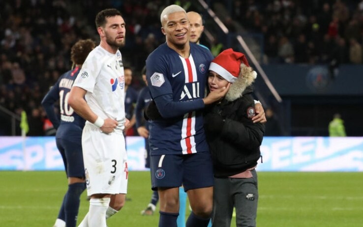 Mbappé abbraccia un giovanissimo invasore