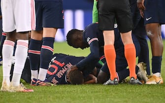 Paris Saint-Germain's Brazilian forward Neymar (C) is assisted by teammates after getting injured during the French L1 football match between Paris Saint-Germain (PSG) and Lyon (OL), on December 13, 2020 at the Parc des Princes stadium in Paris. (Photo by FRANCK FIFE / AFP) (Photo by FRANCK FIFE/AFP via Getty Images)