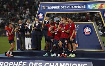 epa09386340 Lille players on the podium celebrate winning the French Supercup Trophee des Champions soccer match between Lille OSC and Paris Saint-Germain (PSG) at the Bloomfield Stadium in Tel Aviv, Israel, 01 August 2021.  EPA/Atef Safadi