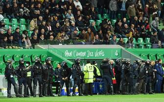 1236054216 French riot police officers stand guard in front of the entrance of the football players' locker rooms, after AS Saint-Etienne supporters launched smoke canisters to protest against the last place of their football club in the ranking of the French L1 championship, prior to the start of the French L1 football match between AS Saint-Etienne and SCO Angers at the Geoffroy Guichard stadium in Saint-Etienne, central France, on October 22, 2021. - Incidents broke out during the pre-match protocol Saint-Etienne/Angers of the 11th day of Ligue 1, caused by the ultras groups of the club stéphanois, and the kickoff of the game scheduled for 21:00 has been delayed. (Photo by PHILIPPE DESMAZES / AFP) (Photo by PHILIPPE DESMAZES/AFP via Getty Images)