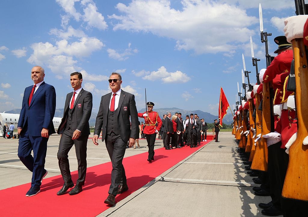 Albanian Prime Minister Edi Rama (L), the captain of Albania's national soccer team, Lorik Cana (C) and Albania's national football team head coach Gianni De Biasi review an honor guard during a welcoming ceremony at Mother Teresa airport in Tirana on June 23, 2016. 
Albania's Euro 2016 squad was welcomed home on June 23 with a formal red-carpet ceremony and National Guard troops on its return from the country's first ever participation at a European Championship. / AFP / GENT SHKULLAKU        (Photo credit should read GENT SHKULLAKU/AFP via Getty Images)