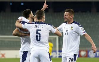 Serbia's forward Aleksandar Mitrovic celebrates with teammates after scoring the opening goal during the FIFA World Cup Qatar 2022 qualification football match Azerbaijan v Serbia in Baku on March 30, 2021. (Photo by TOFIK BABAYEV / AFP) (Photo by TOFIK BABAYEV/AFP via Getty Images)