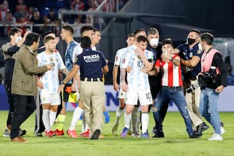 ASUNCION, PARAGUAY - OCTOBER 07: Police officers take action as pitch invaders try to get close to Lionel Messi of Argentina after a match between Paraguay and Argentina as part of South American Qualifiers for Qatar 2022 at Estadio Defensores del Chaco on October 07, 2021 in Asuncion, Paraguay. (Photo by Christian Alvarenga/Getty Images)