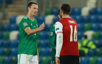 epa08736661 Jonny Evans of Northern Ireland (L) greets Christopher Trimmel of Austria (R) at the end of the UEFA Nations League match between Northern Ireland and Austria in Belfast, Britain, 11 October 2020.  EPA/John McVitty