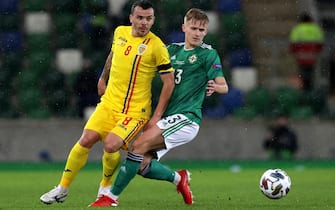 epa08828111 Alistair Mccann of Northern Ireland in action against Dan Nistor of Romania during the UEFA Nations League match between Northern Ireland and Romania in Belfast, Britain, 18 November 2020.  EPA/John McVitty