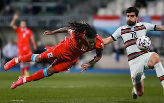 epa09107368 Luxembourg's Gerson Rodrigues (L) scores the 1-0 lead next to Portugal's Ruben Neves (R) during the FIFA World Cup 2022 qualifying soccer match between Luxembourg and Portugal in Luxembourg, 30 March 2021.  EPA/Julien Warnand
