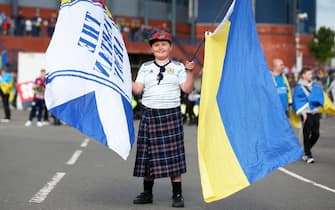 epa09990227 A young supporter of Scotland holds the flags of Scotland and Ukraine ahead of the FIFA World Cup 2022 qualification playoff semi final soccer match between Scotland and Ukraine at Hampden Park in Glasgow, Scotland, Britain, 01 June 2022.  EPA/Robert Perry