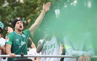 15 May 2022, Bremen: Soccer: 2nd Bundesliga, Werder Bremen - Jahn Regensburg, Matchday 34, wohninvest Weserstadion. Werder players Niclas Füllkrug (l) and Leonardo Bittencourt celebrate promotion with fans in a motorcade on a flatbed truck. Photo: Carmen Jaspersen/dpa - IMPORTANT NOTE: In accordance with the requirements of the DFL Deutsche Fußball Liga and the DFB Deutscher Fußball-Bund, it is prohibited to use or have used photographs taken in the stadium and/or of the match in the form of sequence pictures and/or video-like photo series.