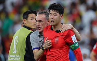 AL RAYYAN, QATAR - NOVEMBER 28:  Son Heung-min of Korea Republic looks dejected as he is consoled by South Korea Head Coach Paulo Bento at full time during the FIFA World Cup Qatar 2022 Group H match between Korea Republic and Ghana at Education City Stadium on November 28, 2022 in Al Rayyan, Qatar. (Photo by Marc Atkins/Getty Images)