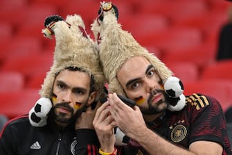 Germany supporters listen to a mobile phone as they wait for the start of the Qatar 2022 World Cup Group E football match between Costa Rica and Germany at the Al-Bayt Stadium in Al Khor, north of Doha on December 1, 2022. (Photo by Glyn KIRK / AFP) (Photo by GLYN KIRK/AFP via Getty Images)