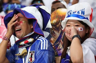 DOHA, QATAR - DECEMBER 01:  Japan fans shed tears of joy alongside a replica world cup trophy during the FIFA World Cup Qatar 2022 Group E match between Japan and Spain at Khalifa International Stadium on December 1, 2022 in Doha, Qatar. (Photo by Marc Atkins/Getty Images)