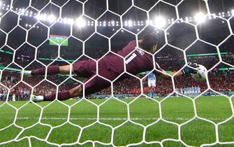 epa10352408 Goalkeeper Yassine Bounou of Morocco saves the shot from Sergio Busquets (L) of Spain during the penalty shoot-out in the FIFA World Cup 2022 round of 16 soccer match between Morocco and Spain at Education City Stadium in Doha, Qatar, 06 December 2022.  EPA/TOLGA BOZOGLU