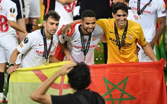 epa08617478 (from left) Munir, Youssef En-Nesyri and goalkeeper Yassine Bounou of Sevilla celebrate after winning the UEFA Europa League final match between Sevilla FC and Inter Milan in Cologne, Germany 21 August 2020.  EPA/Ina Fassbender / POOL