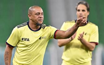 epa10362420 Former Brazilian player Roberto Carlos (L) reacts during the Workers and FIFA Legends soccer match at Al Thumama Stadium in Doha, Qatar, 12 December 2022. FIFA World Cup 2022 guests and volunteers watched workers and FIFA legends playing in a 60-minute match.  EPA/NOUSHAD THEKKAYIL