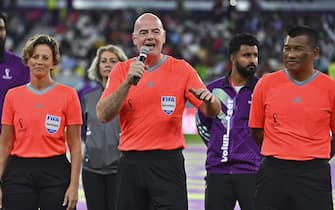 epa10362436 FIFA president Gianni Infantino (C) delivers a speech before officiating the Workers and FIFA Legends soccer match as referee at Al Thumama Stadium in Doha, Qatar, 12 December 2022. FIFA World Cup 2022 guests and volunteers watched workers and FIFA legends playing in a 60-minute match.  EPA/NOUSHAD THEKKAYIL