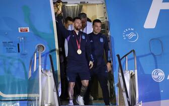 epa10374423 Lionel Messi (C) of the Argentina national soccer team descends a plane with the trophy of Qatar 2022 World Cup accompanied by head coach Lionel Scaloni (R), upon ther arrival to the International Airport of Ezeiza, some 22km of Buenos Aires, Argentina, 20 December 2022.  EPA/RAUL MARTINEZ