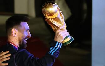 epa10374439 Lionel Messi of the Argentina national soccer team holds the trophy of Qatar 2022 World Cup upon the team's arrival to the International Airport of Ezeiza, some 22km of Buenos Aires, Argentina, 20 December 2022.  EPA/RAUL MARTINEZ