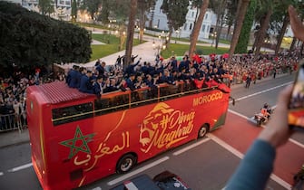 epa10375064 Moroccan national soccer team players cheer during an open top bus parade upon their return from the FIFA World Cup 2022 soccer tournament in Qatar, in Rabat, Morocco, 20 December 2022.  EPA/Jalal Morchidi