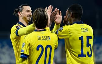 epa09103743 Alexander Isak (R) of Sweden celebrates with team-mate Zlatan Ibrahimovic (L) after scoring the team's second goal during the FIFA World Cup 2022 qualifying soccer match between Kosovo and Sweden in Pristina, Kosovo, 28 March 2021.  EPA/GEORGI LICOVSKI