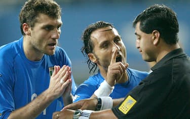 Italy's Angelo Di Livio (C) and Christian Vieri (L) protest as referee Byron Moreno (R) of Ecuador holds both yellow and red cards after he sent Italy's Francesco Totti off in extra time against South Korea during a second round World Cup Finals match in Taejon, June 18, 2002.ANSA/DESMOND BOYLAN