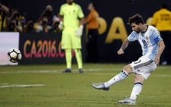 epa05393720 Argentina midfielder Lionel Messi (R) attempts his penalty kick during the COPA America Centenario USA 2016 Cup final soccer match between Argentina and Chile at the MetLife Stadium in East Rutherford, New Jersey, USA, 26 June 2016. After the match, Messi anncounced that he will be retiring from international soccer.  EPA/JASON SZENES