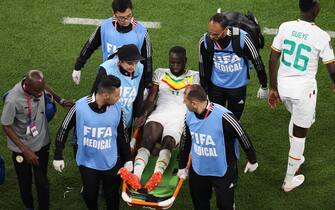 epa10318610 Cheikhou Kouyate of Senegal is brought off the pitch on a stretcher after pickung up an injury during the FIFA World Cup 2022 group A soccer match between Senegal and the Netherlands at Al Thumama Stadium in Doha, Qatar, 21 November 2022.  EPA/Mohamed Messara