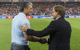 epa09450170 Switzerland's head coach Murat Yakin (L) greets his counterpart Italy's head coach Roberto Mancini ahead of the 2022 FIFA World Cup European Qualifying Group C soccer match between Switzerland and Italy in the St. Jakob-Park stadium in Basel, Switzerland, 05 September 2021.  EPA/JEAN-CHRISTOPHE BOTT