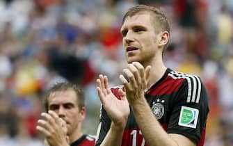 epa04283979 Per Mertesacker (R) of Germany reacts after the FIFA World Cup 2014 group G preliminary round match between the USA and Germany at the Arena Pernambuco in Recife, Brazil, 26 June 2014. (RESTRICTIONS APPLY: Editorial Use Only, not used in association with any commercial entity - Images must not be used in any form of alert service or push service of any kind including via mobile alert services, downloads to mobile devices or MMS messaging - Images must appear as still images and must not emulate match action video footage - No alteration is made to, and no text or image is superimposed over, any published image which: (a) intentionally obscures or removes a sponsor identification image; or (b) adds or overlays the commercial identification of any third party which is not officially associated with the FIFA World Cup)  EPA/YURI KOCHETKOV   EDITORIAL USE ONLY