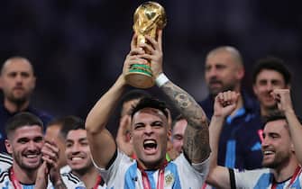 epa10373071 Lautaro Martinez (C) of Argentina lifts the World Cup trophy after winning the FIFA World Cup 2022 Final between Argentina and France at Lusail stadium, Lusail, Qatar, 18 December 2022.  EPA/Friedemann Vogel