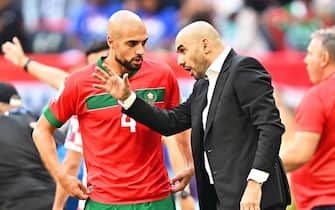 epa10322136 Morocco's head coach Walid Regragui (R) gives instructions to Sofyan Amrabat (L) during the FIFA World Cup 2022 group F soccer match between Morocco and Croatia at Al Bayt Stadium in Al Khor, Qatar, 23 November 2022.  EPA/Noushad Thekkayil