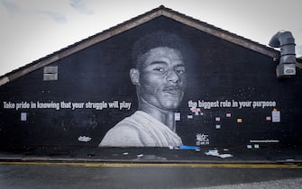 The Marcus Rashford mural displayed on the side of a cafe in Withington, south Manchester on the 6th of August 2021, Manchester, United Kingdom.  The mural has attracted huge numbers of people since the Euro 2020 final between England and Italy on 11 July and the subsequent racist abuse levied at Rashford and other black players on the England team. Based on a photograph by Daniel Cheetham, the painting of Marcus Rashford was completed in 2020 by street artist Akse, in collaboration with the street art project Withington Walls, to commemorate the footballer's work to reduce child hunger. (photo by Andrew Aitchison / In pictures via Getty Images)