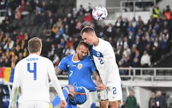 epa10202320 Denis Alibec (C) of Romania in action against Finnish players Robert Ivanov (L) and Leo Vaisanen (R) during the UEFA Nations League soccer match between Finland and Romania in Helsinki, Finland, 23 September 2022.  EPA/KIMMO BRANDT