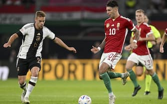 epa10202187 Joshua Kimmich (L) of Germany in action against Dominik Szoboszlai (C) of Hungary during the UEFA Nations League soccer match between Germany and Hungary in Leipzig, Germany, 23 September 2022.  EPA/FILIP SINGER
